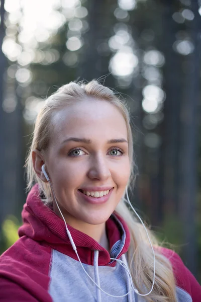 Running girl with earphones - woman runner listening to music in