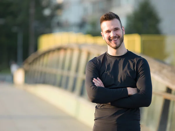 Portrait of Sport and fitness runner man resting on bridge after