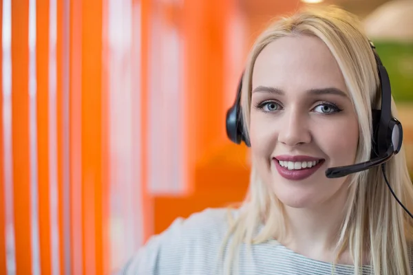 Portrait of support phone operator in headset at workplace. To p