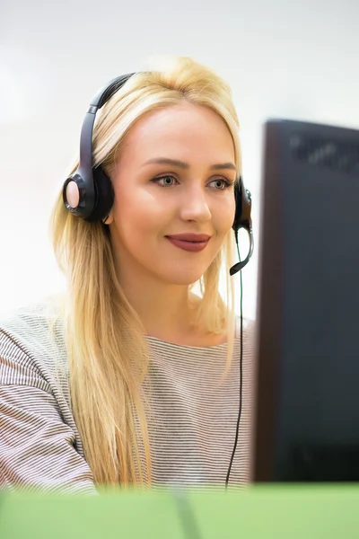 Attractive young woman in suit sitting at call center office and