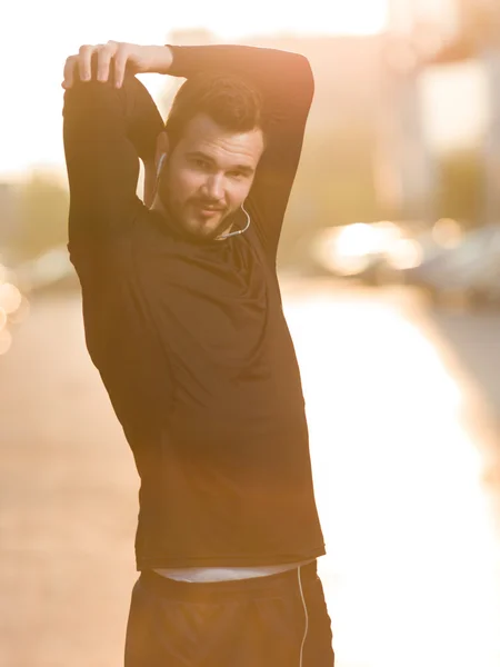 Man stretching outdoors in city before jogging