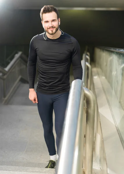 Portrait of male runner jogging fast down the bridge with copy s