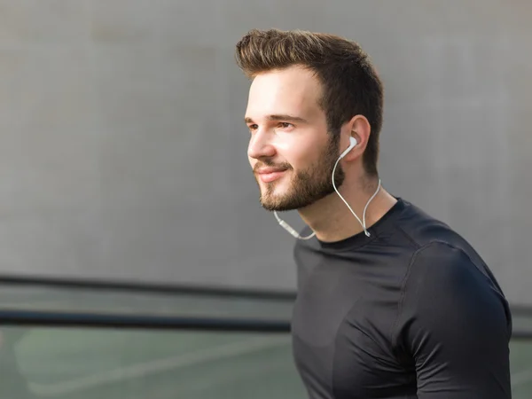 Portrait of male runner jogging fast down the bridge with copy s