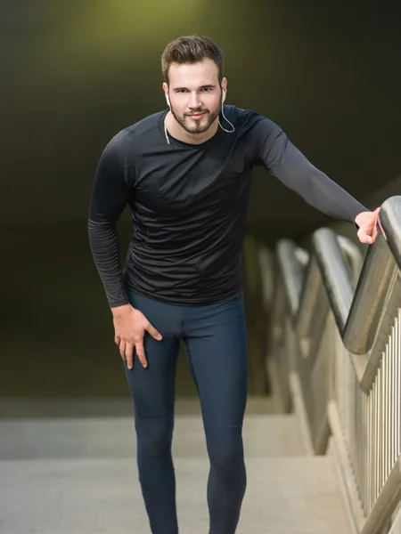 Portrait of male runner jogging fast down the bridge with copy s