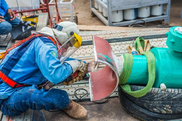 Construction worker welding underground valve gas pipeline