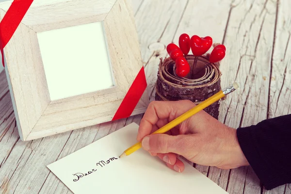 Writing a letter for Mother\'s Day, with hearts and frame