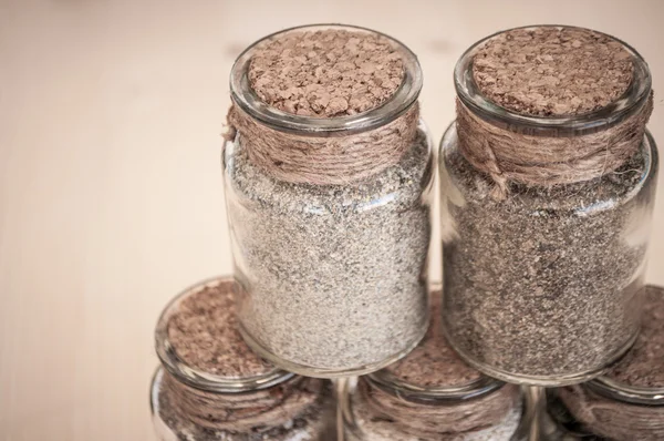 Small glass jars with sand and stones from the beach