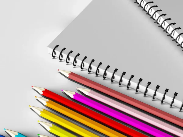 Notebook with colored pencils on White background
