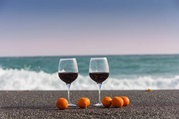 Red wine and tangerines on the sand