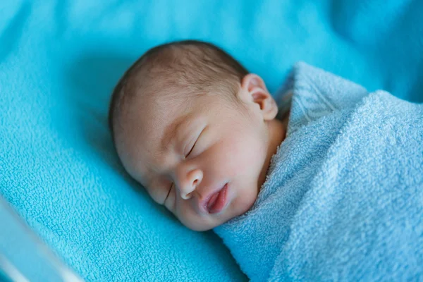 Newborn baby Asia  while sleeping covered with blue cloth