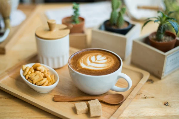 Hot latte art  with cactus in coffee shop on table wooden