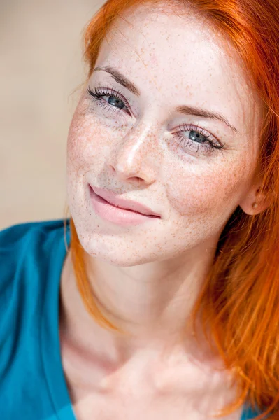Closeup portrait of a dreamy redhead freckled girl
