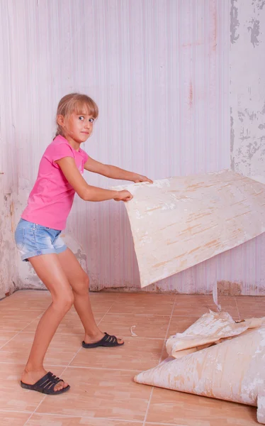 Girl remove old wallpapers from wall
