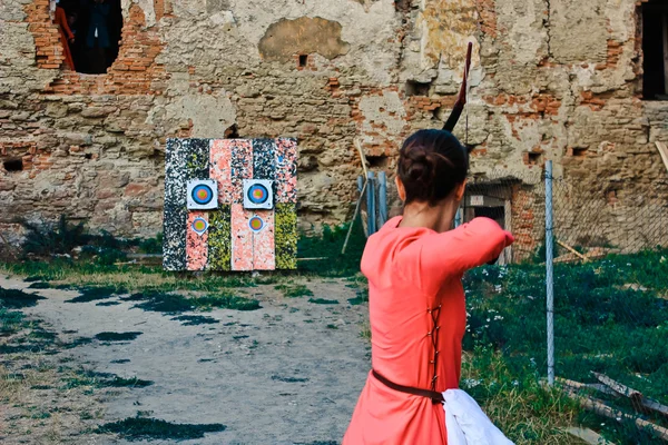 Girl shoots a bow at a target