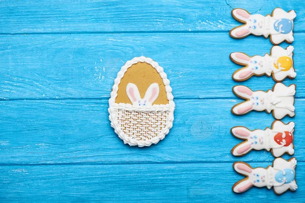 Colorful easter rabbit cookies on blue wooden background