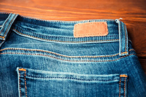 Blue jeans with half of back pocket and brown leather tag