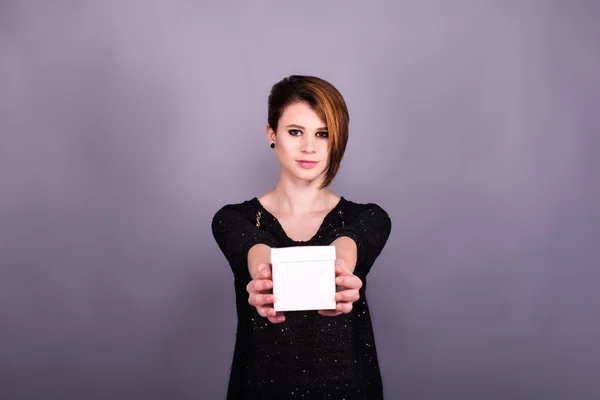 Girl with short haircut holding white box