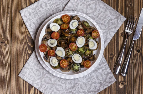 Salad with cherry tomatoes mushrooms and quail eggs with blue cheese dressing