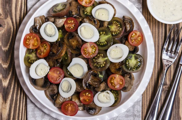 Salad with cherry tomatoes mushrooms and quail eggs with blue cheese dressing