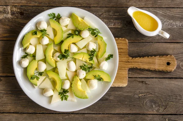 Salad with melon and avocado mini mozzarella orange-honey dressing