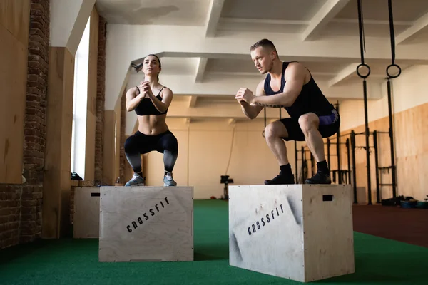 Man and woman jumping on boxes