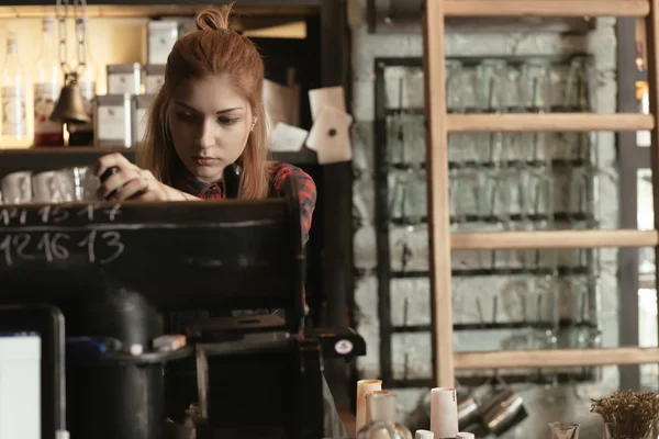 Young female bartender pouring beer