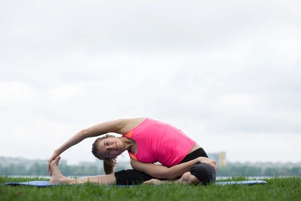 Young woman doing stretching exercises at open air