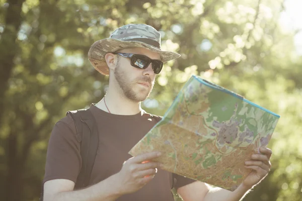 Male explorer looking at a map outdoors