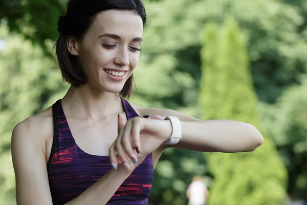 Sports woman look at watch in park before jogging