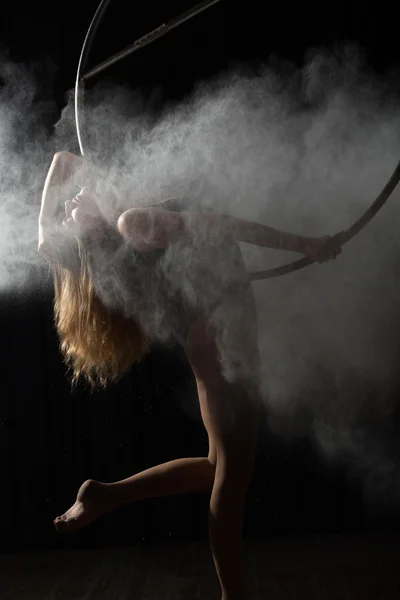 Professional acrobatic woman on aerial hoop with flour