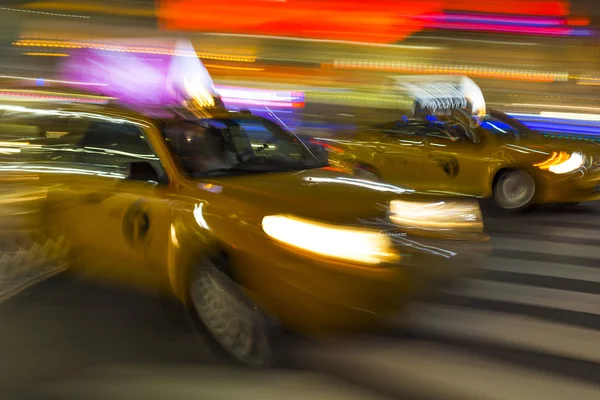 Blurry abstract photo of yellow taxi cabs in motion in Manhattan