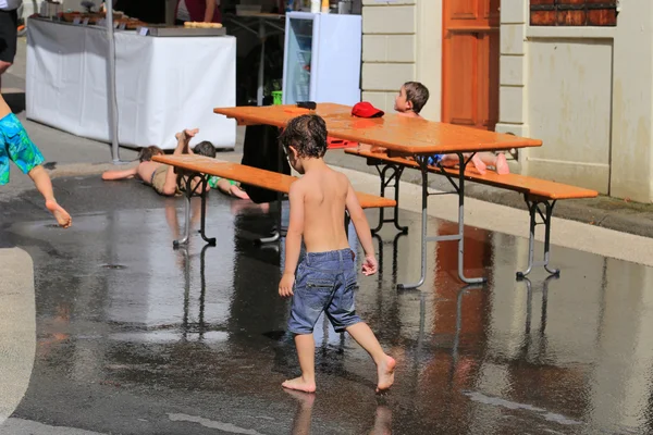 Children playing with water during hot day in small town of Grandvaux, Bourg-en-Lavaux