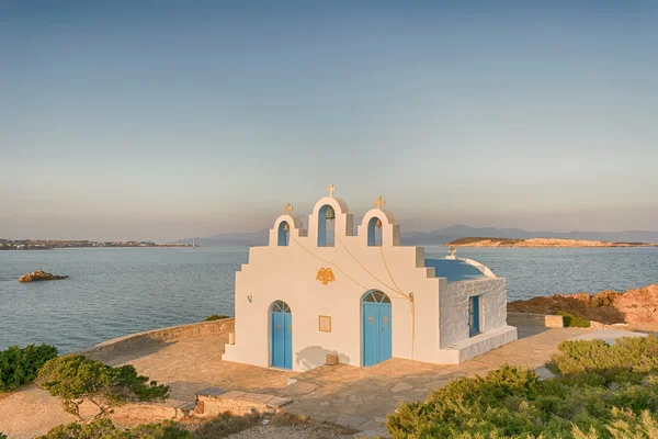 Local church in Pirgaki in Paros island against the blue Aegean sea. A beautiful landscape.