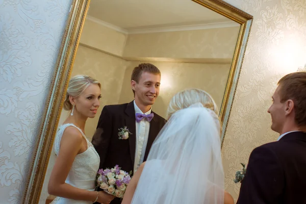 Wedding couple are watching in the mirror