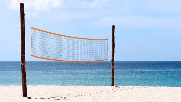 Volleyball net at beach. A volleyball net on beach with blue sea, clear and sunny sky.