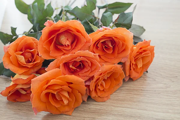 Selective focus of fresh orange roses on wooden background with copy space for some text, Concept of love, Valentines Day background, wedding day