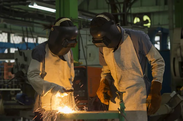 Workers with protective mask welding steel