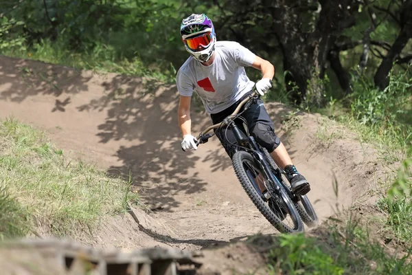 Sportsman in sportswear on a mountain bike rides on the special trail