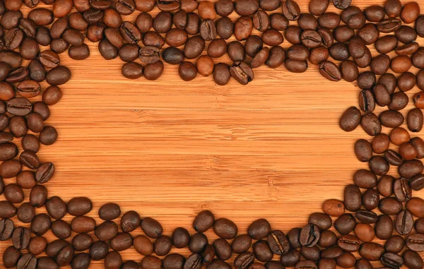 Coffee beans border frame over bamboo wood background