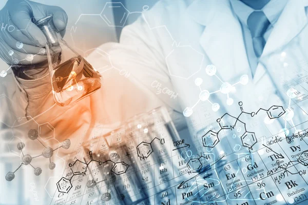 A researcher is doing his chemical lab research at laboratory with chemical equations and periodic table background.