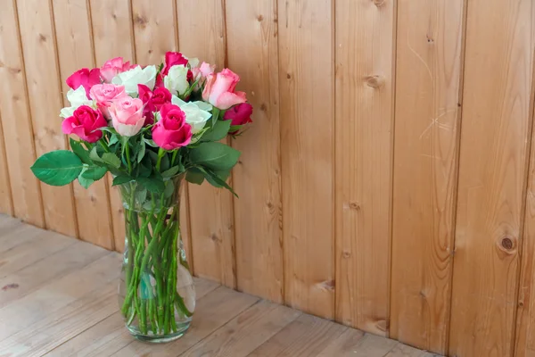 Vase with flowers standing near the window