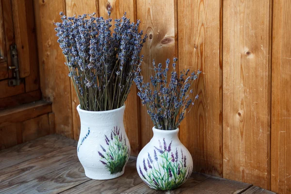 Lavender flowers are in a vase on the window