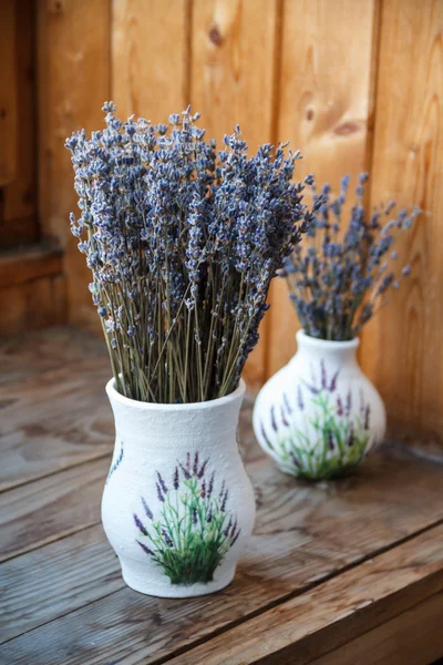 Lavender flowers are in a vase on the window