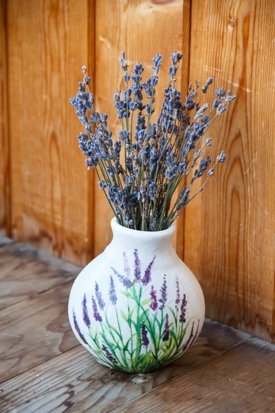 Lavender flowers are in a vase on the window