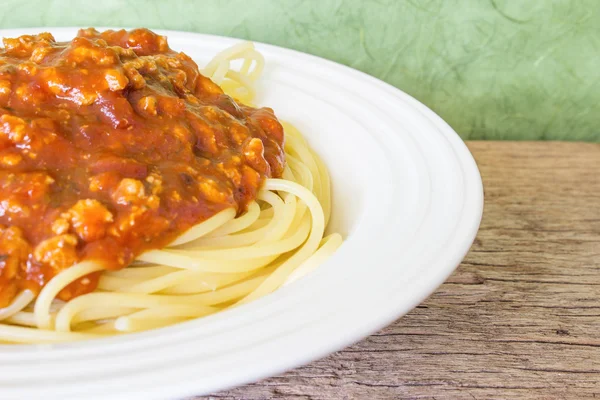 The red sauce spaghetti in a white dish.