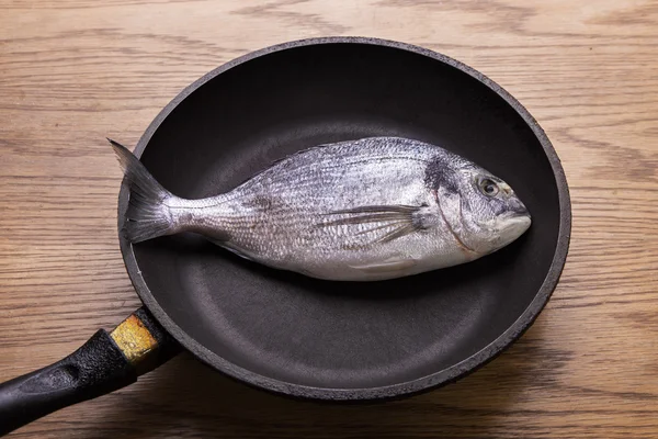 Dorado fish in a frying pan,  healthy food. top vew