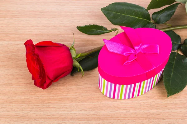 A gift and a red rose on the table