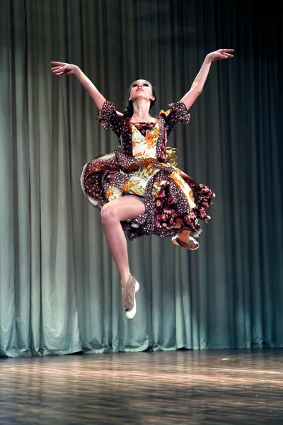 Girl dancer on stage jumping in the air and his arms outstretche