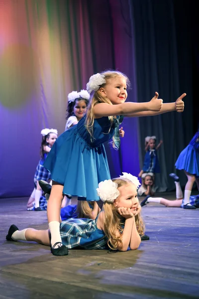 A girl shows a thumbs-up - she was a dancer on the stage.