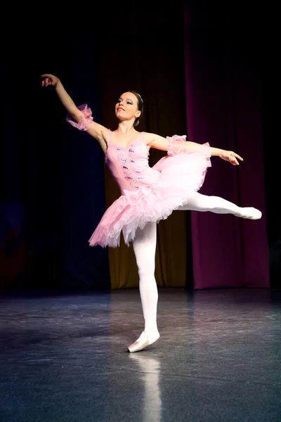 Ballet - dancer in pink raised a hand and a leg up, she smiles.